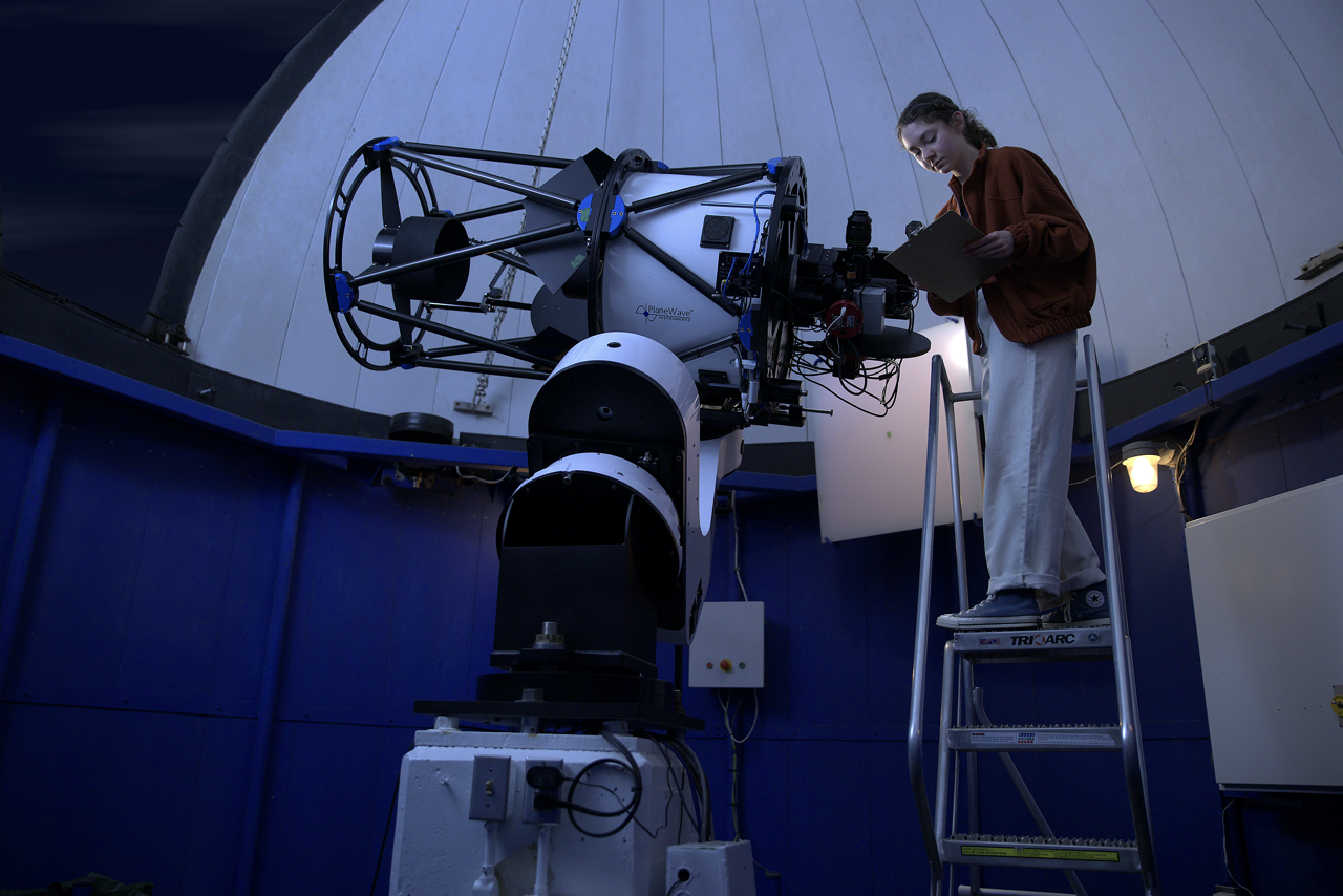 Astrophysics student looking at telescope