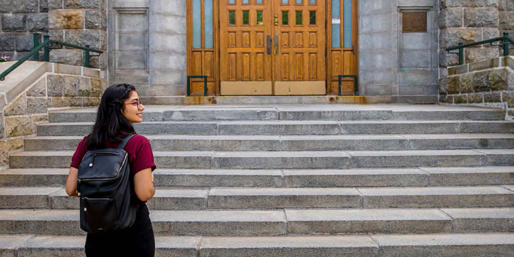 A student walking up to the McNally Entrance